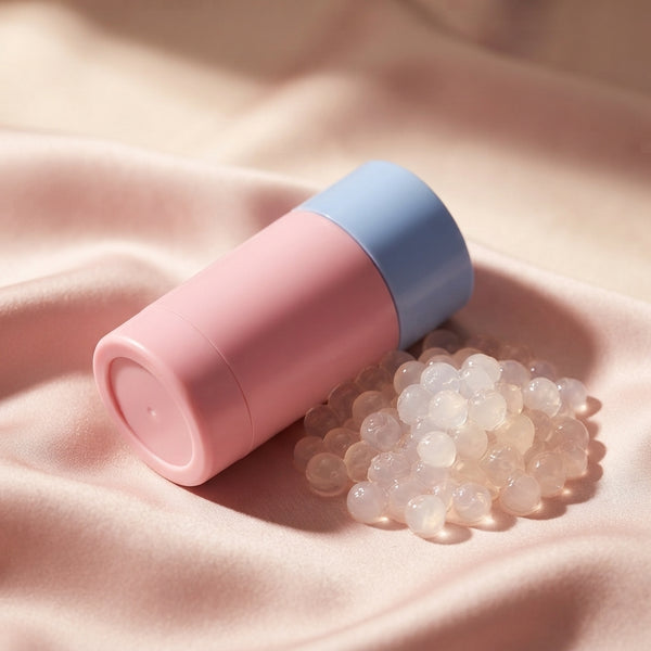 KORMESIC collagen stick next to translucent pearls on a soft blush-pink silk surface representing skin structure.